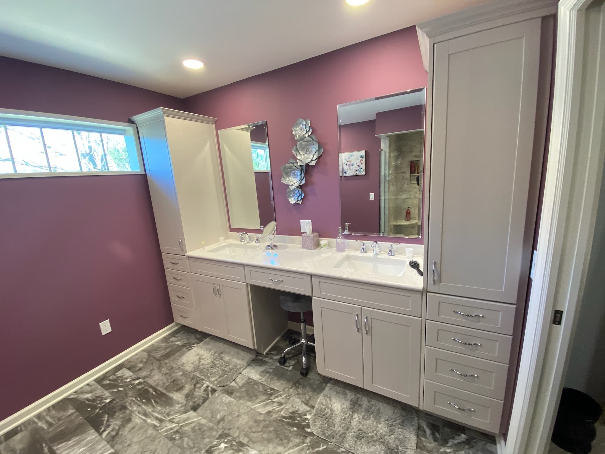 A bright transitional bathroom features a double vanity with light gray shaker cabinets, white engineered quartz countertops, and chrome hardware
