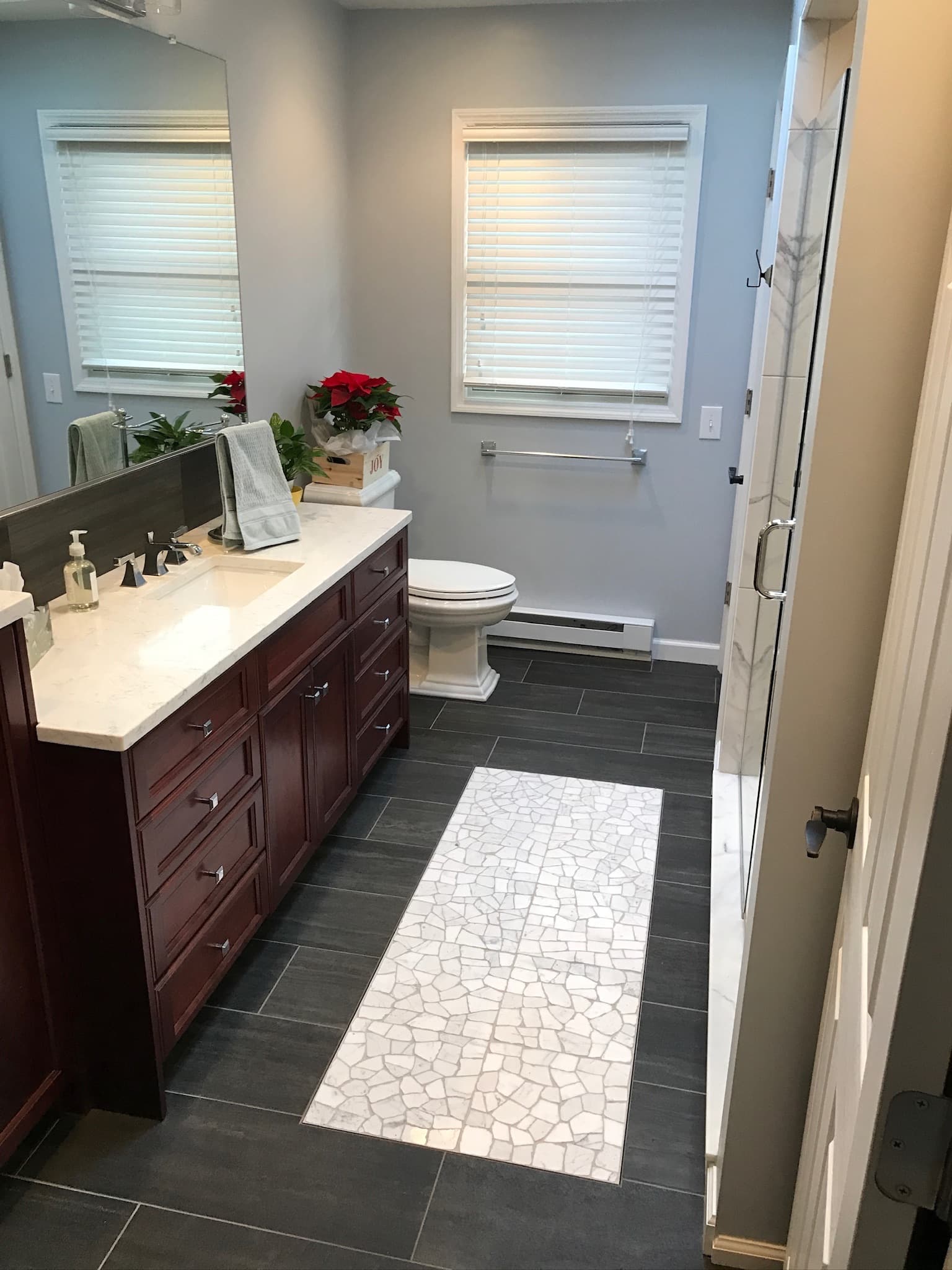 Transitional bathroom with a dark wood single vanity and white quartz countertop, light blue walls, and a walk-in shower