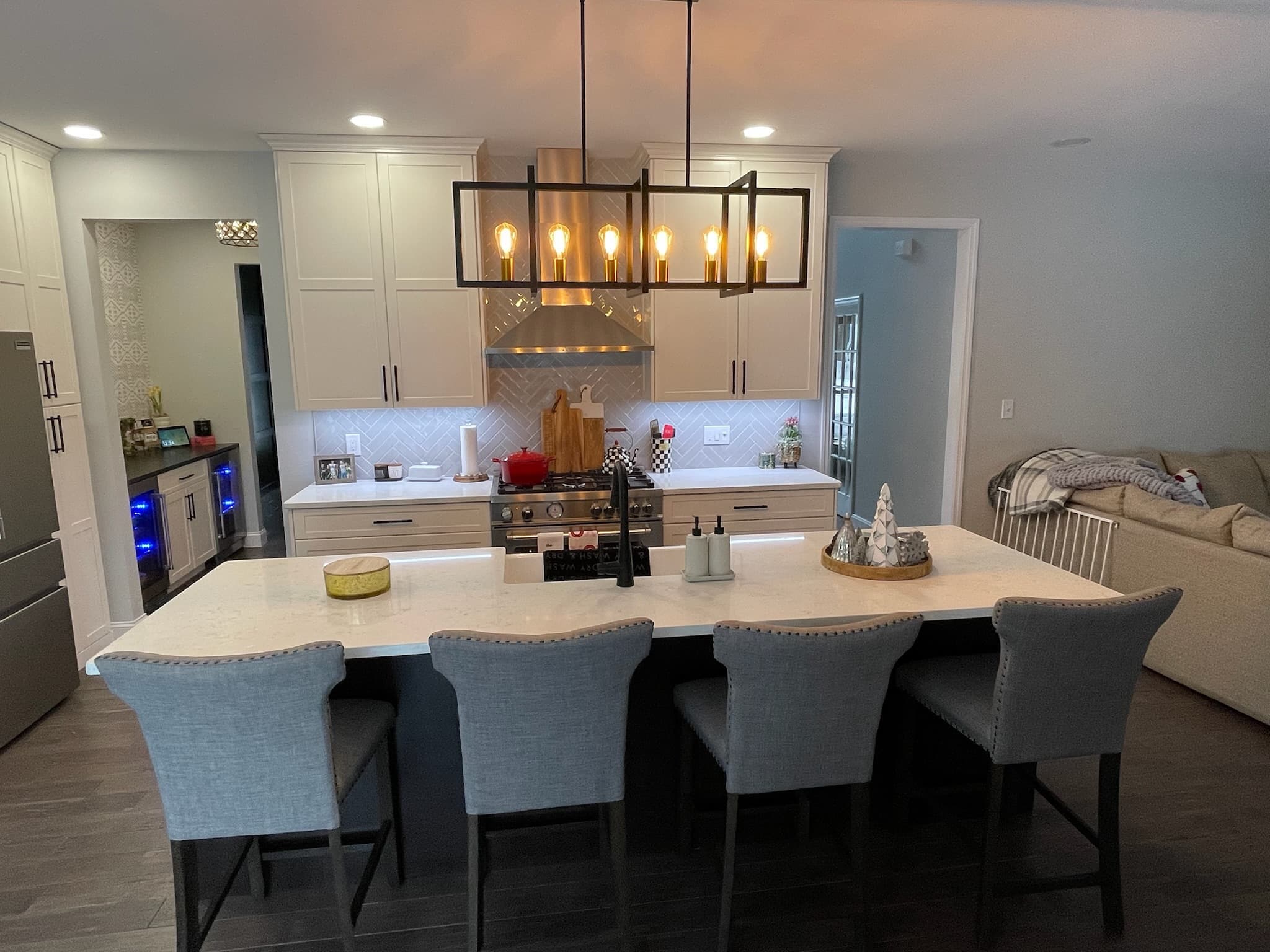 A transitional kitchen with a large island and two-tone shaker cabinets, featuring white upper cabinets and light beige lower cabinets