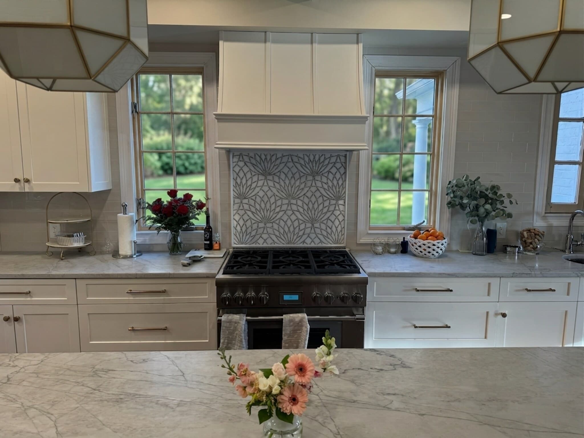 Range wall with custom wood hood and glass-front cabinets