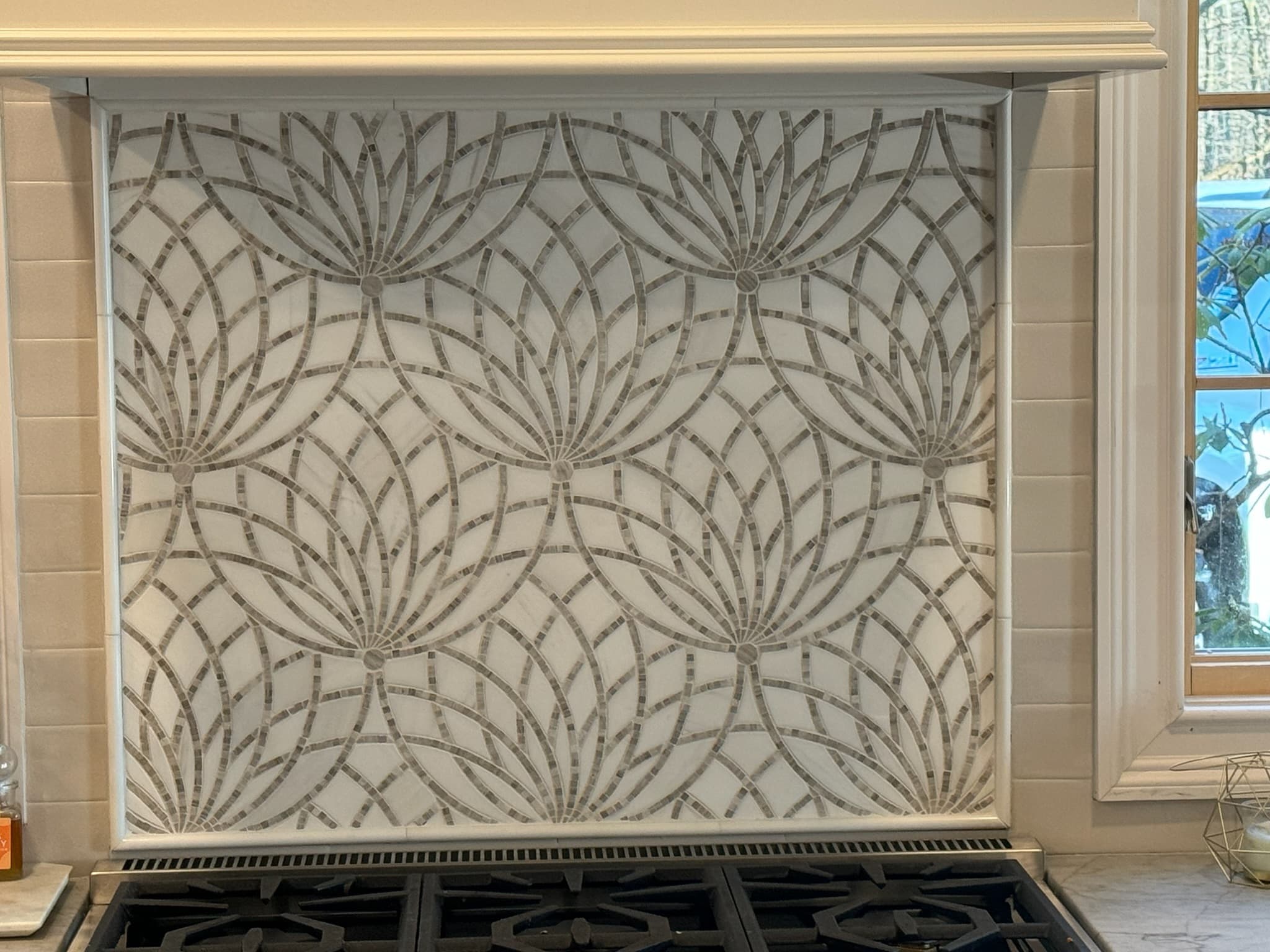 Mosaic tile medallion backsplash behind the range
