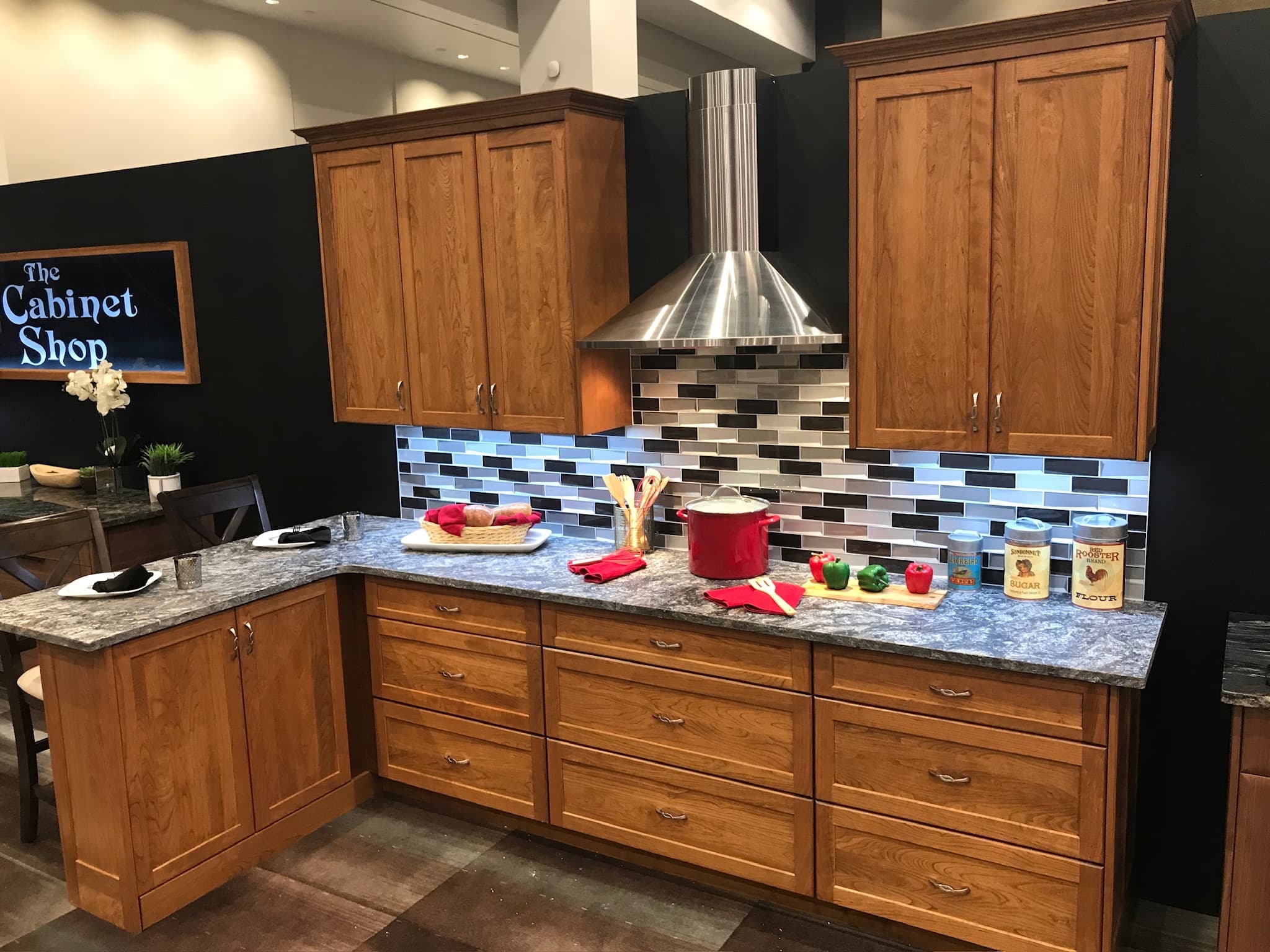 A transitional kitchen with medium wood recessed panel cabinets, granite countertops, and a modern subway tile backsplash